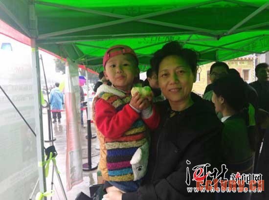 市民带着孩子来购买爱心梨。