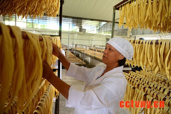 5月16日，广西昭平县木格乡一家生产腐竹的企业工人在摊晾腐竹。